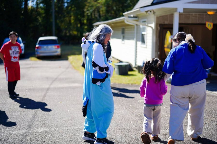 A friend in a costume walking with a little girl