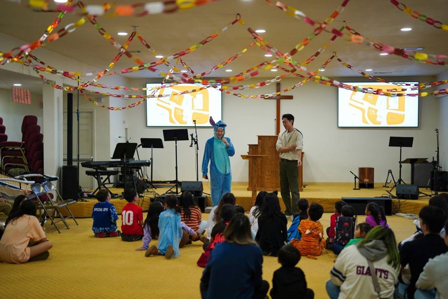 Children in costumes watching a skit in the sanctuary
