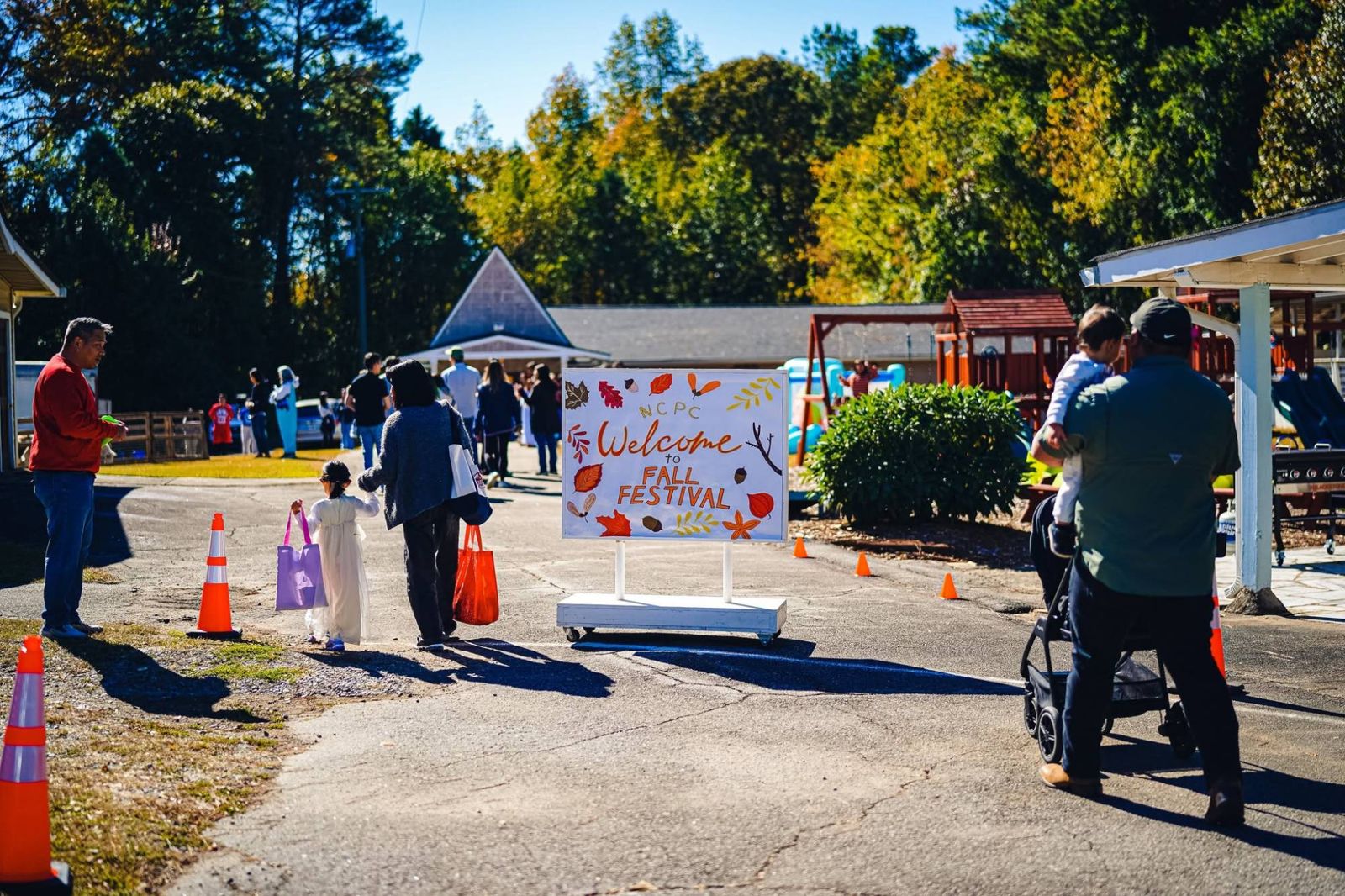 Families arriving past the Welcome to Fall Festival sign